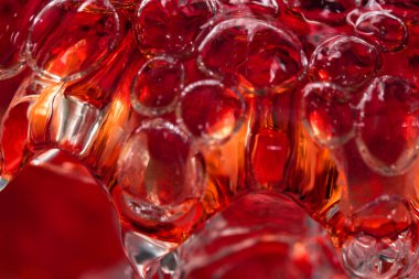 Güçlü bir deredeki soyut makro fotoğraf suyu kırmızı bir vazoyu hava kabarcıklarının oluşumuyla doldurur.