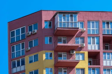 Mavi bir yay gökyüzünün arka planına karşı çok katlı, çok katlı bir apartmanın parçası, emlak objesi