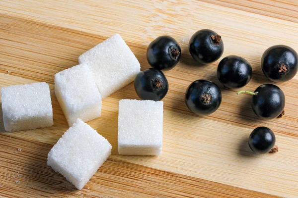 Reife Schwarze Johannisbeeren Auf Dem Küchentisch Neben Zuckerwürfeln Nahaufnahme Makrofotografie — Stockfoto