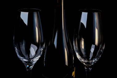 Siyah arka planda iki boş bardakla güçlendirilmiş kırmızı üzüm şarabı.