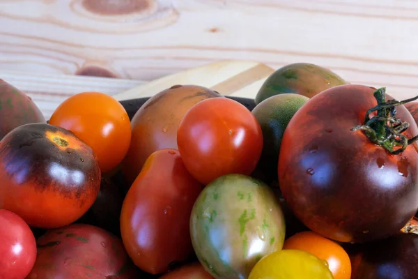 異なる品種の多色熟した小さなトマトは 木製のテーブルの上にありますクローズアップマクロ写真 — ストック写真