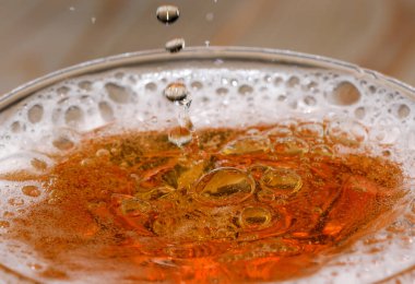 Cam bir mermide hafif bira damlaları ve baloncukları yakın çekim makro fotoğraf.