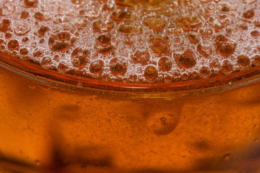 Cam bir mermide hafif bira damlaları ve baloncukları yakın çekim makro fotoğraf.