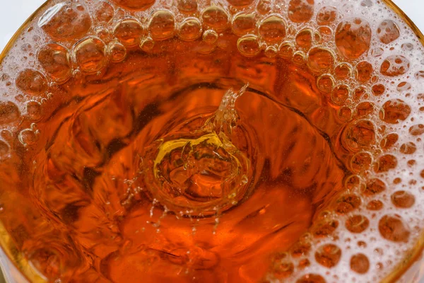 Cam bir mermide hafif bira damlaları ve baloncukları yakın çekim makro fotoğraf.