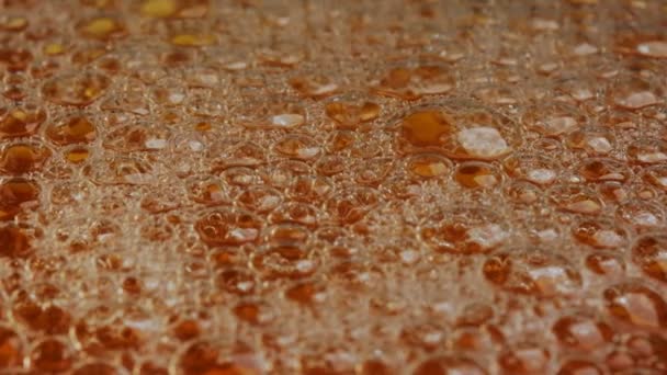 玻璃球中的淡淡啤酒的滴落和气泡发射慢动作的宏视频剪辑 — 图库视频影像