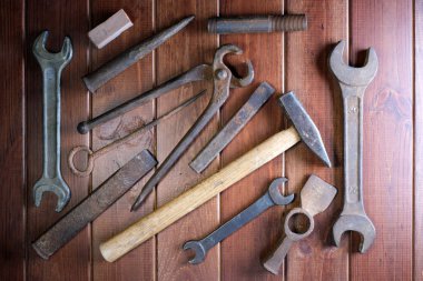 Eski çilingir demir aletleri koyu kahverengi ahşap arka planda