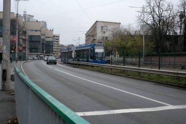 Kiev 'de Kasım öğleden sonra bulutlu bir tramvay ve yoldan geçen arabalar görülüyor..