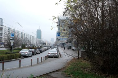 Gri bir sonbahar gününde, Kiev 'in sessiz caddeleri park etmiş arabaları ve uzak binaları gösteriyor..