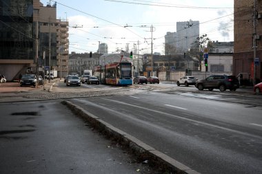 Araçlarla dolu kalabalık bir şehir caddesinde renkli bir tramvay hareket ediyor. 24 Kasım 2025 Kyiv, Ukrayna