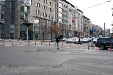 Yayalar, araba ve dükkanlarla dolu yoğun bir şehir kavşağında yol alırlar. 24 Kasım 2025 Kyiv, Ukrayna