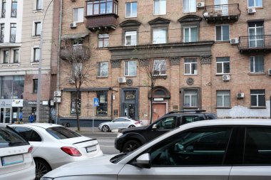 Arabalar hareketli bir şehir caddesinde, modern yaşam ve mimariyi harmanlayarak ilerliyorlar. 24 Kasım 2025 Kyiv, Ukrayna