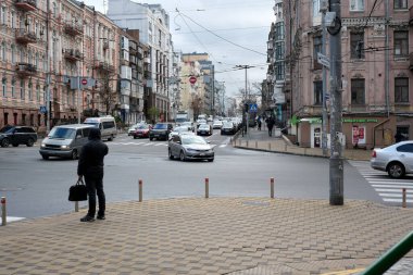 Bir kişi köşede beklerken araçlar hareketli bir kavşakta yol alırlar. 24 Kasım 2025 Kyiv, Ukrayna