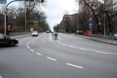 Arabalar bulutlu gökyüzü olan boş bir yol boyunca yol alırlar. 24 Kasım 2025 Kyiv, Ukrayna