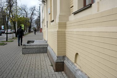 Gri gökyüzünün altındaki zarif sarı bir yapının yakınındaki kaldırımda öylesine bir gezinti. 24 Kasım 2025, Kyiv, Ukrayna, Shevchenko Bulvarı