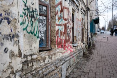 Duvar yazılarıyla kaplı yıpranmış duvarlar zamanın geçtiği ve değiştiği hakkında hikayeler anlatır. 24 Kasım 2025, Kyiv, Ukrayna, Shevchenko Bulvarı