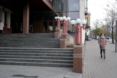 İlkbaharda şık binaların yanında bir kişi sakin bir şekilde kaldırımda yürür. 24 Kasım 2025, Kyiv, Ukrayna, Shevchenko Bulvarı