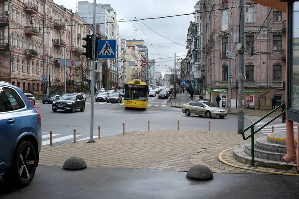 Araçlar ve yayalar bulutlu gökyüzünün altında hareketli bir şehir köşesinde yol alırlar. 24 Kasım 2025 Kyiv, Ukrayna