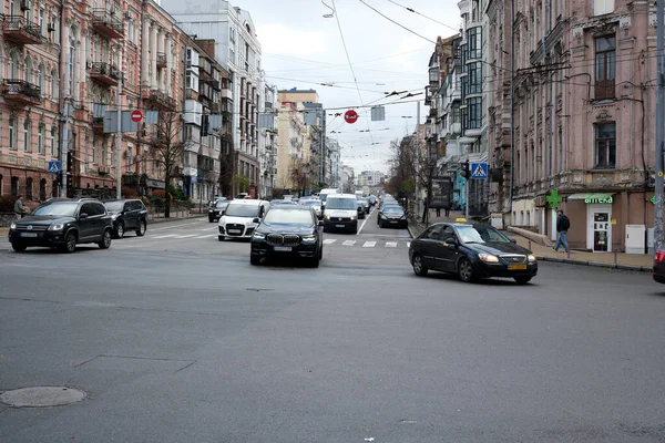 Yayalar yürürken arabalar tarihi binalarla dolu hareketli bir caddede yol alıyorlar. 24 Kasım 2025 Kyiv, Ukrayna