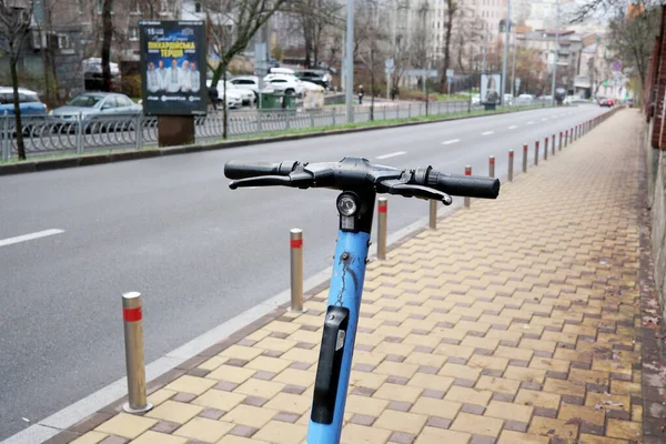 Parlak mavi bir scooter kışın sakin bir şehir caddesinde bir sonraki yolculuğunu bekliyor. 24 Kasım 2025 Kyiv, Ukrayna