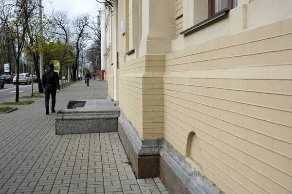 Gri gökyüzünün altındaki zarif sarı bir yapının yakınındaki kaldırımda öylesine bir gezinti. 24 Kasım 2025, Kyiv, Ukrayna, Shevchenko Bulvarı