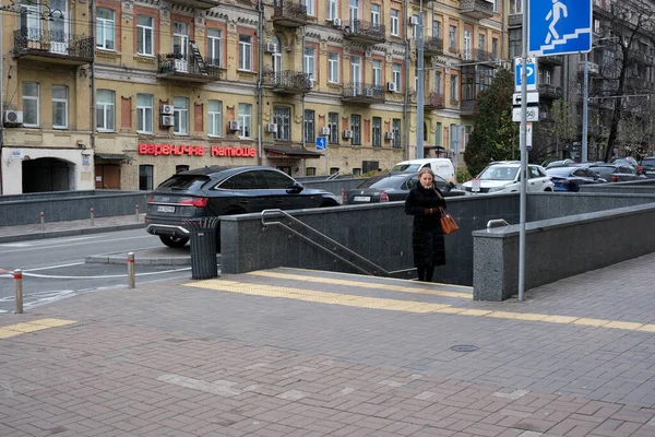 Bir kadın arabalarla dolu kalabalık bir şehir caddesine doğru yürüyor. 24 Kasım 2025, Kyiv, Ukrayna, Shevchenko Bulvarı