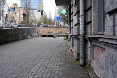 Gri gökyüzünün altında grafiti ve arabaların olduğu sessiz bir sokak sahnesi. Kyiv, Ukrayna, 26 Kasım 2025.