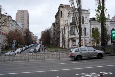 Eski binalar, insanların kentsel bozulma ve yaşamı sergilediği sessiz bir cadde boyunca uzanır. Kyiv, Ukrayna, 26 Kasım 2025.