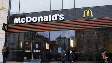 İnsanlar kalabalık bir fast food restoranının önünde toplanıyor, yemeklerini yiyor ve sohbet ediyorlar. Khreshhatyk, Kyiv, Ukrayna. 26 Kasım 2025.