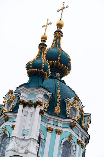 Altın kubbeler güzel bir şekilde gri gökyüzüne doğru yükselirler, karmaşık detaylar sergilerler..