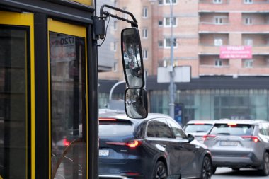 Trafikte bekleyen bir şehir otobüsü, yakınlardaki canlı şehir yaşamını yansıtıyor. Kyiv, Ukrayna. 12 Aralık 2025.