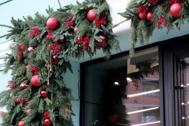 Parlak kırmızı süsler ve yeşillik ziyaretçiler için neşeli bir karşılama yaratır. Kyiv, Ukrayna. 12 Aralık 2025.