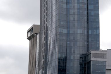 Uzun binalar bulutlu bir gökyüzüne karşı duruyor, parlak camlar ve eşsiz bir mimari. Kyiv, Ukrayna. 12 Aralık 2025.