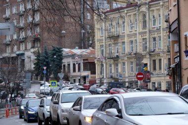 Araçlar gri gökyüzünün altındaki tarihi binaların yakınındaki kalabalık caddede kuyruk oluşturuyorlar. Kyiv, Ukrayna. 12 Aralık 2025.