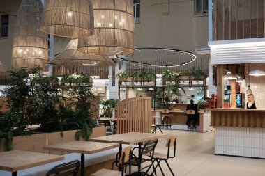 Modern pazar alanı ahşap aksanlar, asılı ışıklar ve yemyeşil bitkiler içerir. Besarabsky Pazarı. Kyiv, Ukrayna. 16 Aralık 2025.