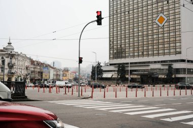 Arabalar bulutlu bir günde yüksek bir binanın yakınındaki trafik ışıklarında beklerler. Kyiv, Ukrayna. 16 Aralık 2025.