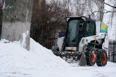 Kar temizleme aracı kışın karlı bir şehir parkında yol açmak için çalışır. Hidropark, Kyiv, Ukrayna, 6 Ocak 2026.