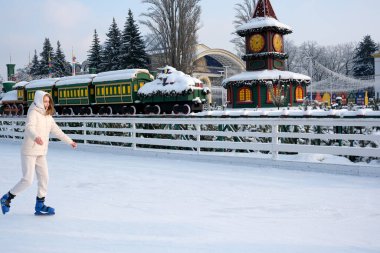 Buz patencisi, kış harikalar diyarında donmuş yüzeyde zarifçe süzülür. Kyiv, Ukrayna, Ukrayna Expocenter 'ı. 14 Ocak 2026.