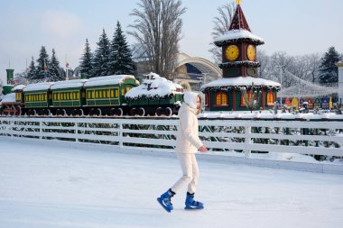 Bir insan kış neşesiyle çevrili buzlu topraklarda zarifçe paten kayar. Kyiv, Ukrayna, Ukrayna Expocenter 'ı. 14 Ocak 2026.