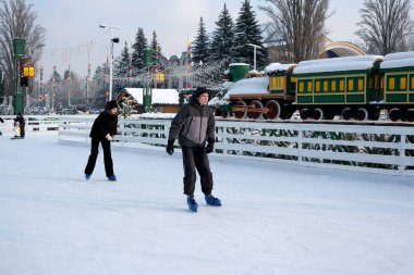 İki patenci, kışın harikalar diyarında parıldayan buz pateni pistinde zarifçe süzülüyor. Kyiv, Ukrayna, Ukrayna Expocenter 'ı. 14 Ocak 2026.