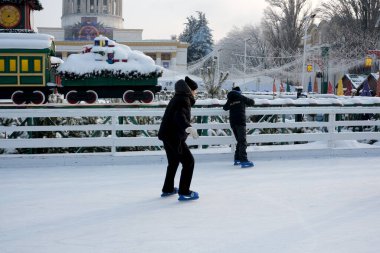 Neşeli çocuklar, karlı bir festival sahnesiyle çevrili buzda zarifçe kayıyorlar. Kyiv, Ukrayna, Ukrayna Expocenter 'ı. 14 Ocak 2026.