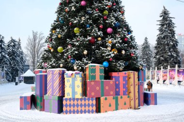 Parlak bir şekilde paketlenmiş hediyeler kışın güzel dekore edilmiş bir Noel ağacının etrafını sarıyor. Kyiv, Ukrayna, Ukrayna Expocenter 'ı. 14 Ocak 2026.