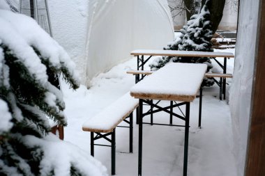Beyaz karla kaplanmış banklar açık havada sakin bir kış inzivası yaratır..