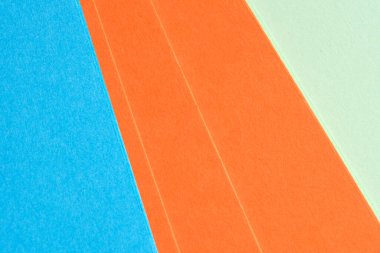 Parlak renkli kağıtlar istiflenmiş, canlı turuncu ve mavi sergileniyordu..