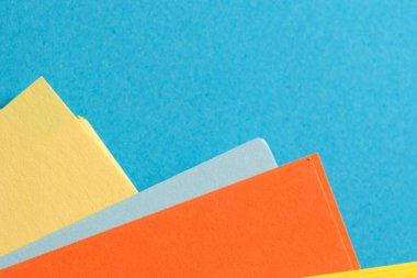 Parlak renkli çarşaflar, rahatlatıcı mavi bir arkaplan karşısında eğlenceli bir şekilde düzenlenir.