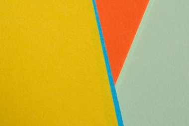 Kağıdın parlak renkleri çarpışıyor ve keskin açılarla canlı bir geometrik görüntü oluşturuyor..