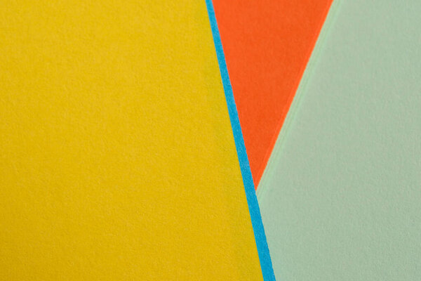 Яркие цвета бумаги сталкиваются, формируя живой геометрический дисплей с острыми углами.