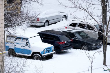 Kar park halindeki arabaları kaplıyor, sessiz mahalleyi kış harikalar diyarına çeviriyor..