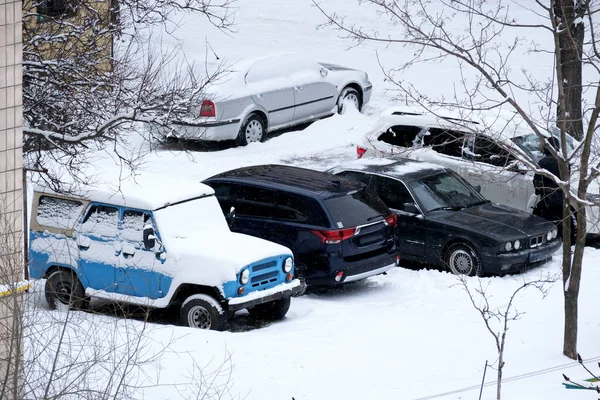 Kar park halindeki arabaları kaplıyor, sessiz mahalleyi kış harikalar diyarına çeviriyor..