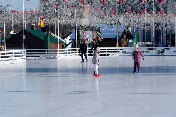 Ilık bir kış gününde parlak dekorasyonların altında çocuklar parlak buzların üzerinde süzülür. Kyiv, Ukrayna. 21 Şubat 2026. Ukrayna Ulusal Kompleks Expocenter, Maslenitsa