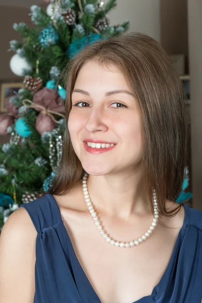 Ritratto di una ragazza carina su uno sfondo decorato albero di Natale — Foto Stock